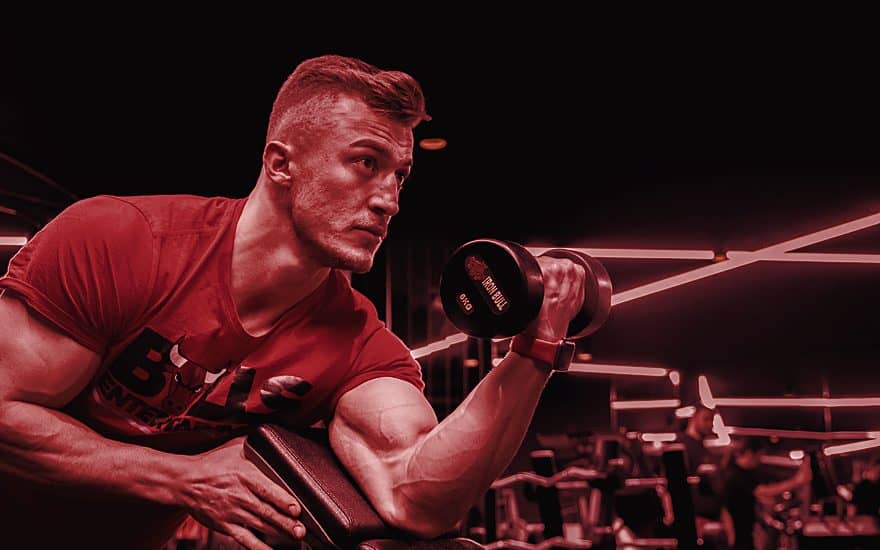 Athlete resting between sets in a dark gym